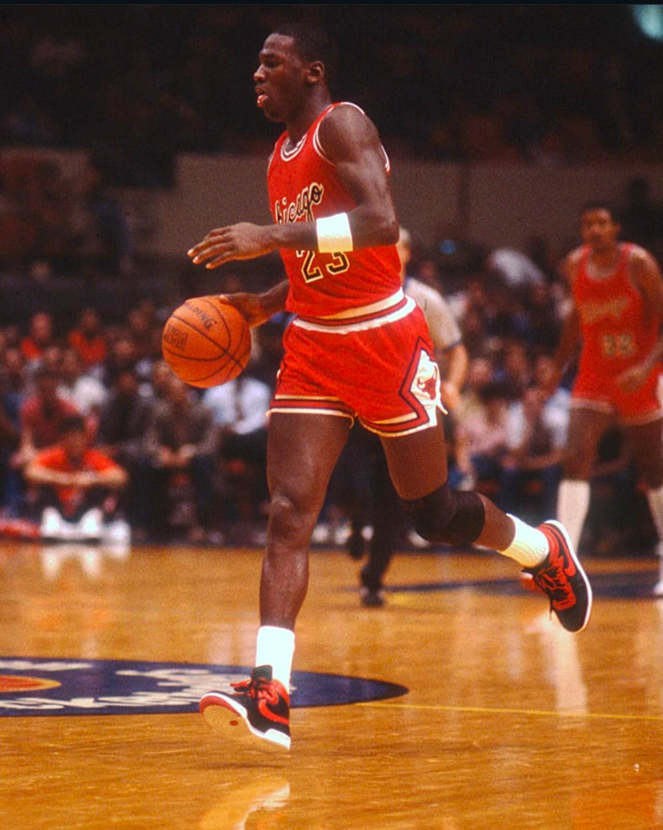 Michael Jordan wearing black and red Nike Air Ship sneakers against the New York Knicks on October 18, 1984